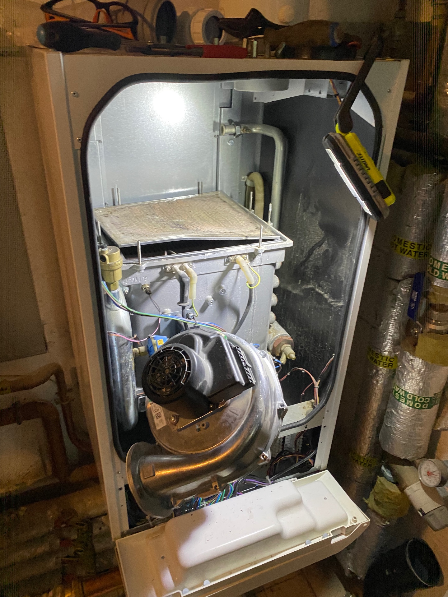 Commercial boiler internal components showing burner chamber and heat exchanger during maintenance cleaning